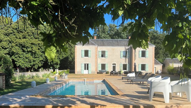 A pool area with lounge chairs and a building with green shutters in the background. - A charming Domaine de La Béchetière, located 2h15 from Paris! (Parcé-sur-Sarthe)