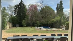 A patio with outdoor seating, a view of a garden, and a small pond. - A charming Domaine de La Béchetière, located 2h15 from Paris! (Parcé-sur-Sarthe)