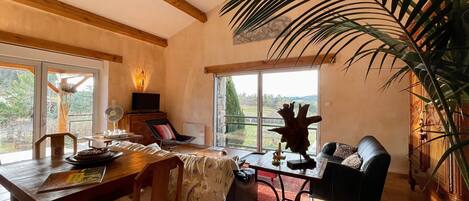 Un comedor con una mesa de madera, sillas y un amplio ventanal con vistas al exterior.