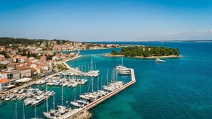 A coastal town with a marina filled with boats, a small island with trees, and buildings along the waterfront. - DUNATOVI DVORI Heritage Hotel (Preko)