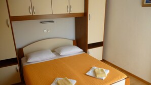 Hotellihuone, jossa on sänky, kaksi tyynyä ja pääty.