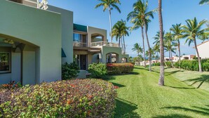 A resort with a modern building, a well-maintained lawn, and several palm trees. - Tropical Paradise in Luxurious 1br, 2ba Ground Floor Unit, Garden View, Palms 801 (Kihei)