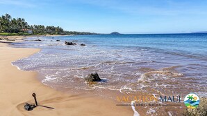 A beach with clear blue water, sandy shore, and a forested area in the background. - Tropical Paradise in Luxurious 1br, 2ba Ground Floor Unit, Garden View, Palms 801 (Kihei)