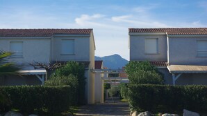 Un sentiero conduce a una fila di edifici di due piani con una montagna sullo sfondo.