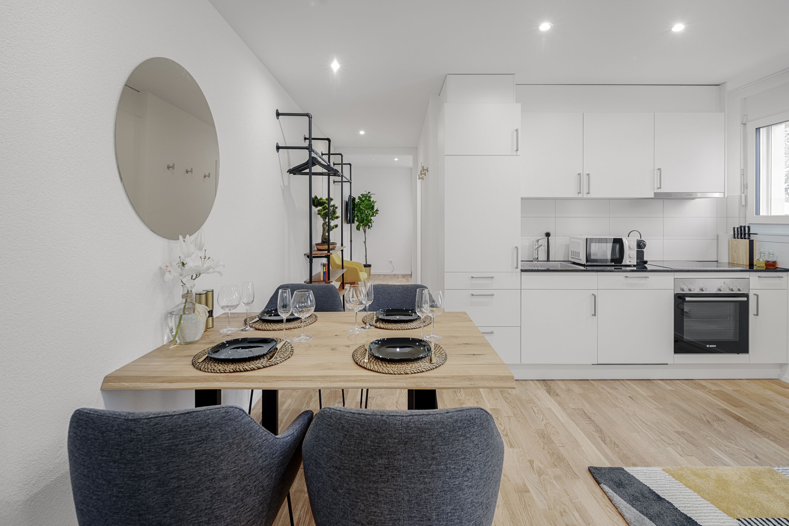 A modern kitchen with white cabinets, a microwave, and an oven.
