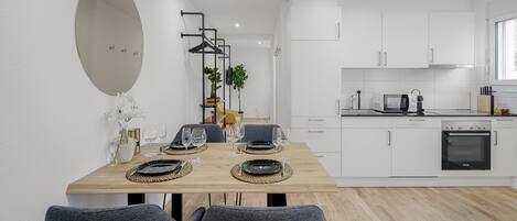 A modern kitchen with white cabinets, a microwave, and an oven.