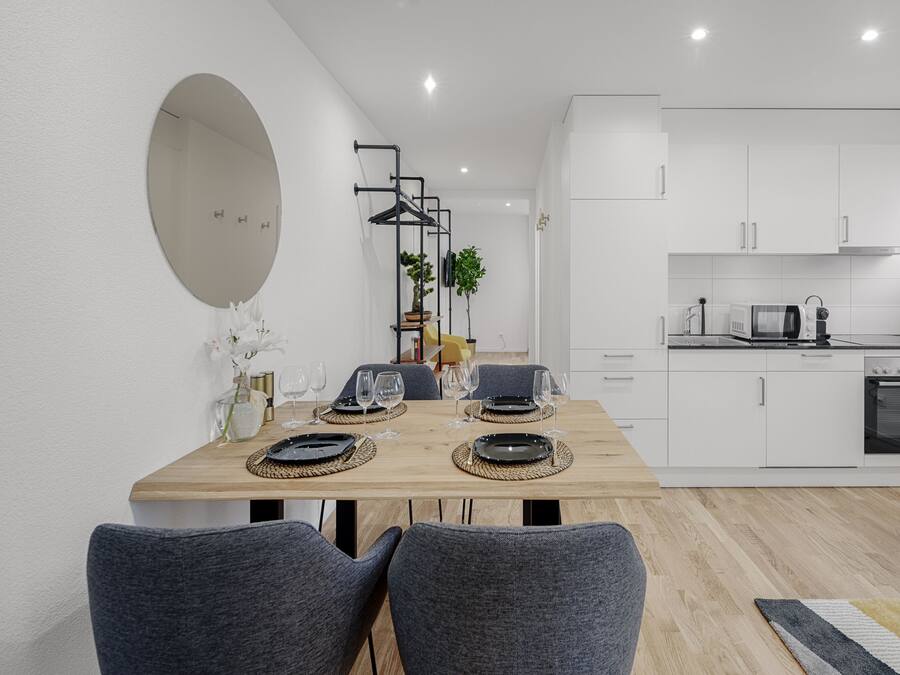 A modern kitchen with white cabinets, a microwave, and an oven.