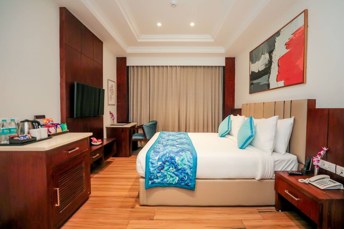 Una habitación de hotel con cama, mesita de noche y escritorio con silla.