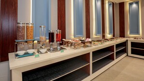 Montaje de bufé con diferentes alimentos y recipientes.