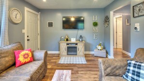A living room with a fireplace, sofas, and a television. - Laurna Dune (Gary)