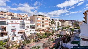 Zona residencial con edificios de varios pisos, balcones y cielo despejado.