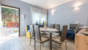 A modern dining area with a table, chairs, and a sofa. - Vacation Home "Ibiscus Rosa 1" with Mountain View, Terrace & A/C (Geremeas)