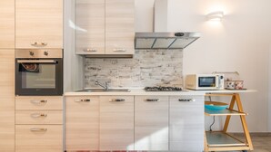 A modern kitchen with a built-in oven, microwave, and gas stove. - Vacation Home "Ibiscus Rosa 1" with Mountain View, Terrace & A/C (Geremeas)