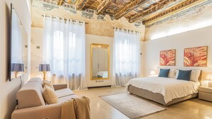 A spacious bedroom with a large bed, a sofa, a mirror, and artwork on the walls. - Rovelli 41 in Como With 2 Bedrooms and 3 Bathrooms (Como)