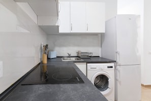 Une cuisine moderne équipée d’un lave-linge, d’un évier et d’un lave-vaisselle intégrés.