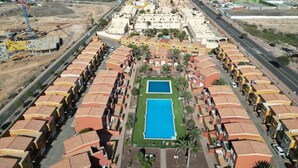 Un resort con varias piscinas, un patio central y vistas del paisaje circundante.