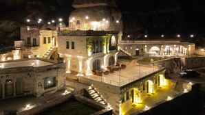 A historic building with multiple levels, stone architecture, and illuminated staircases. - Cappadocia Secret Hill Cave Suites (Nevsehir)