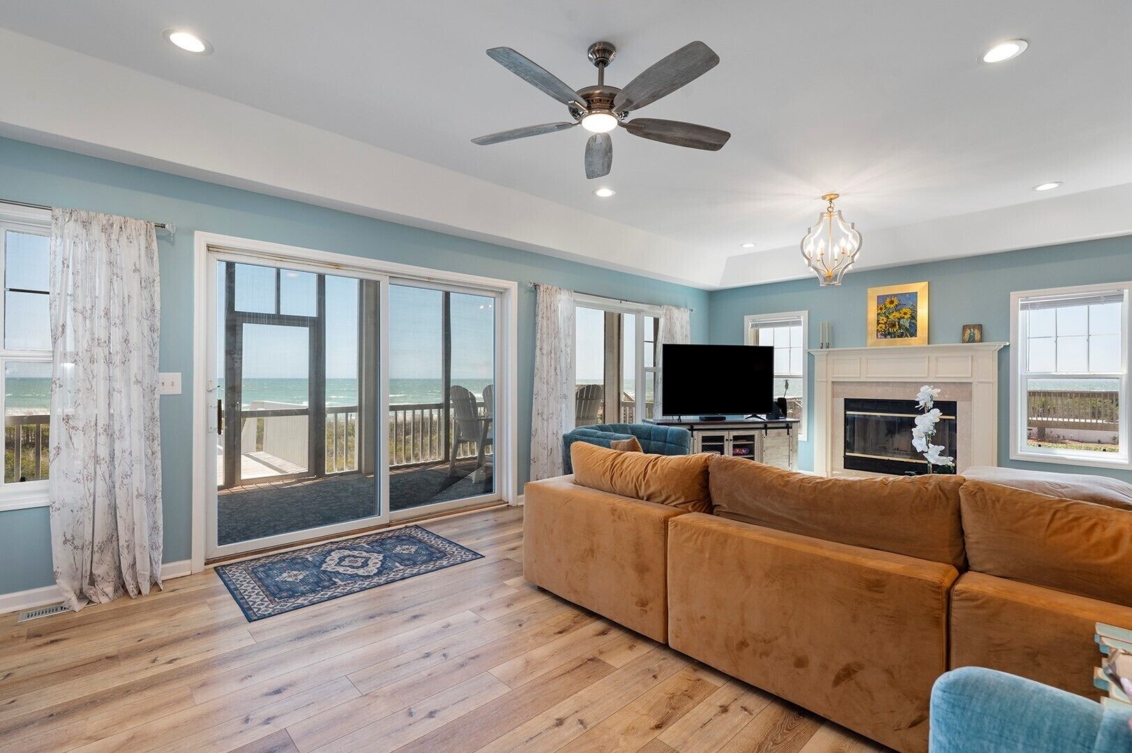 A spacious living room with a large sofa, a flat-screen TV, and a fireplace.