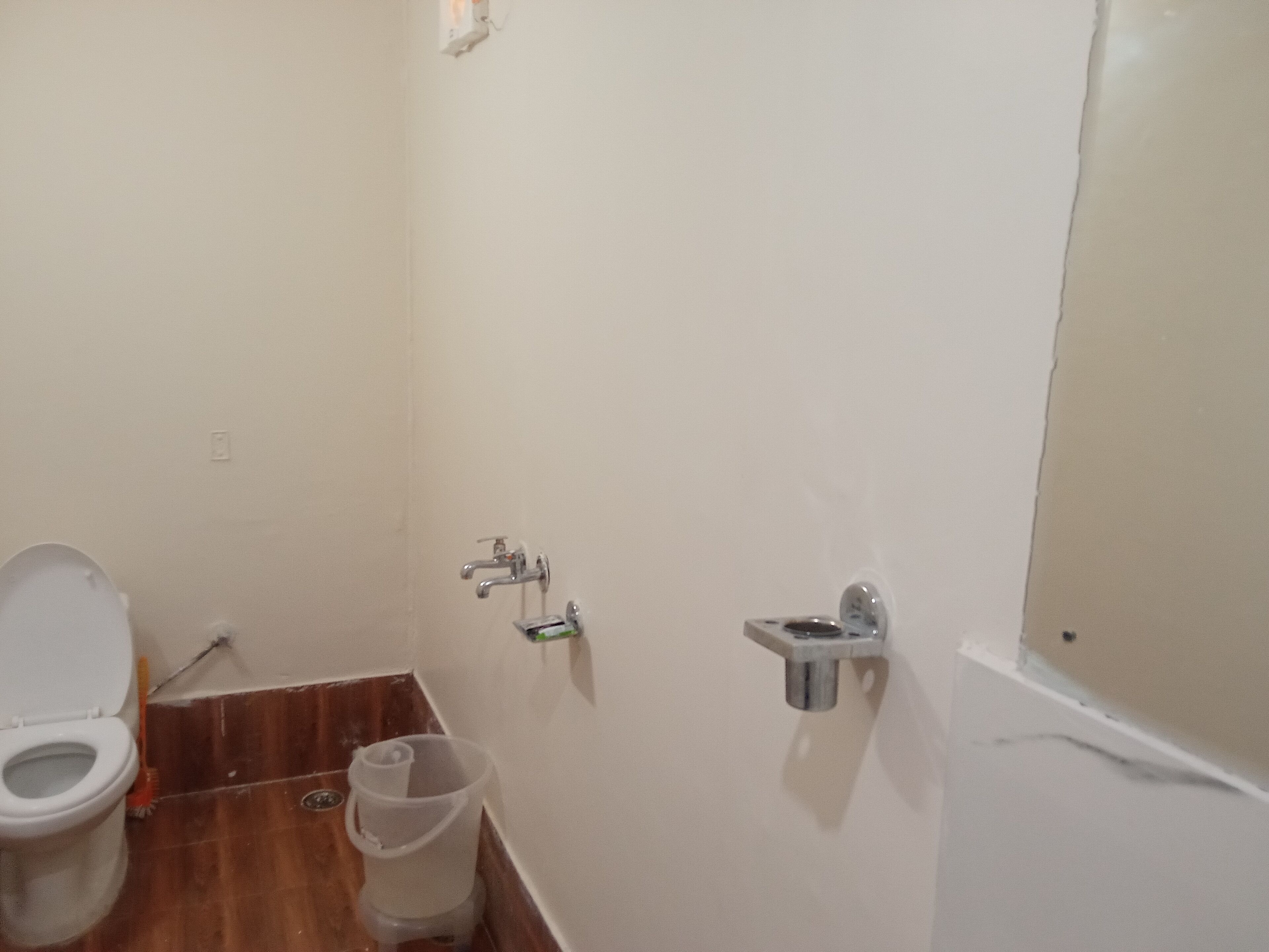 A small bathroom with a toilet, a sink, and a shower area.