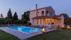 A two-story house with a swimming pool, outdoor seating, and a fire feature. - Country Villa Verde (Corfu)
