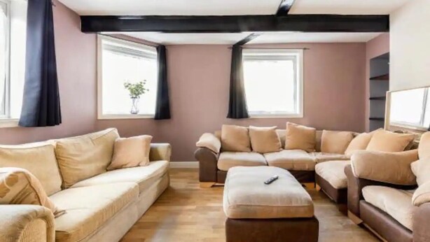 A living room with a beige sofa, a brown sofa, and a wooden coffee table. - Abbey House SW London for Big Groups (Colliers Wood)