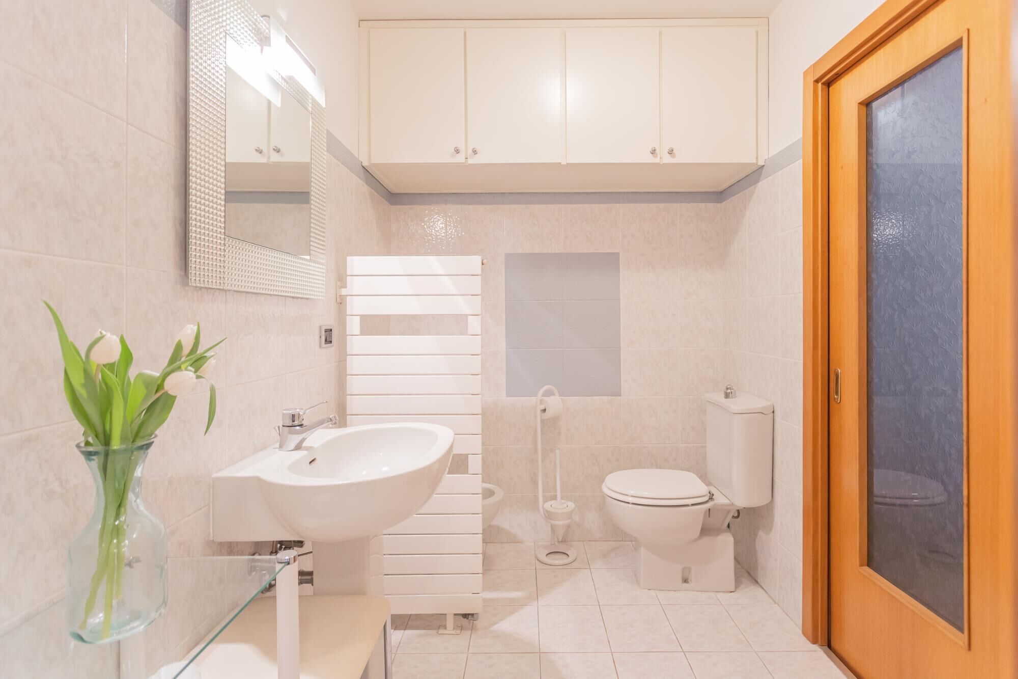 A modern bathroom with a large sink, toilet, and shower.