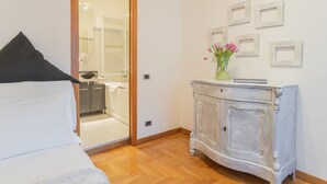 Une chambre à coucher comprenant un lit, une coiffeuse avec un miroir, une commode et un mur orné de tableaux.