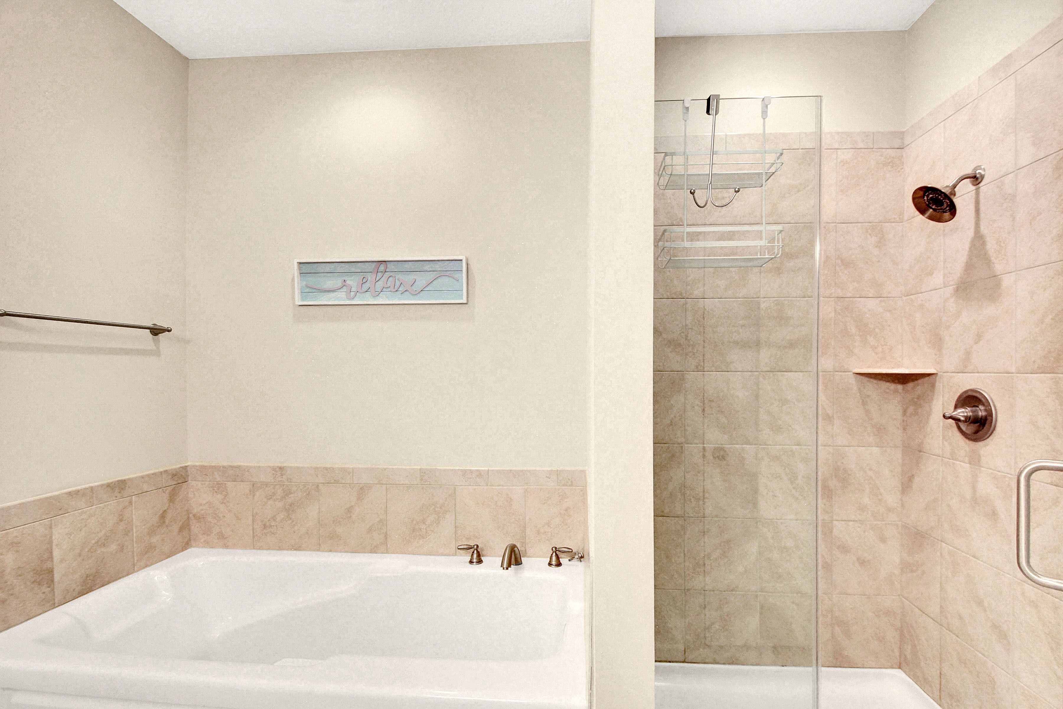 A modern bathroom with a bathtub, a shower area, and a towel rack.