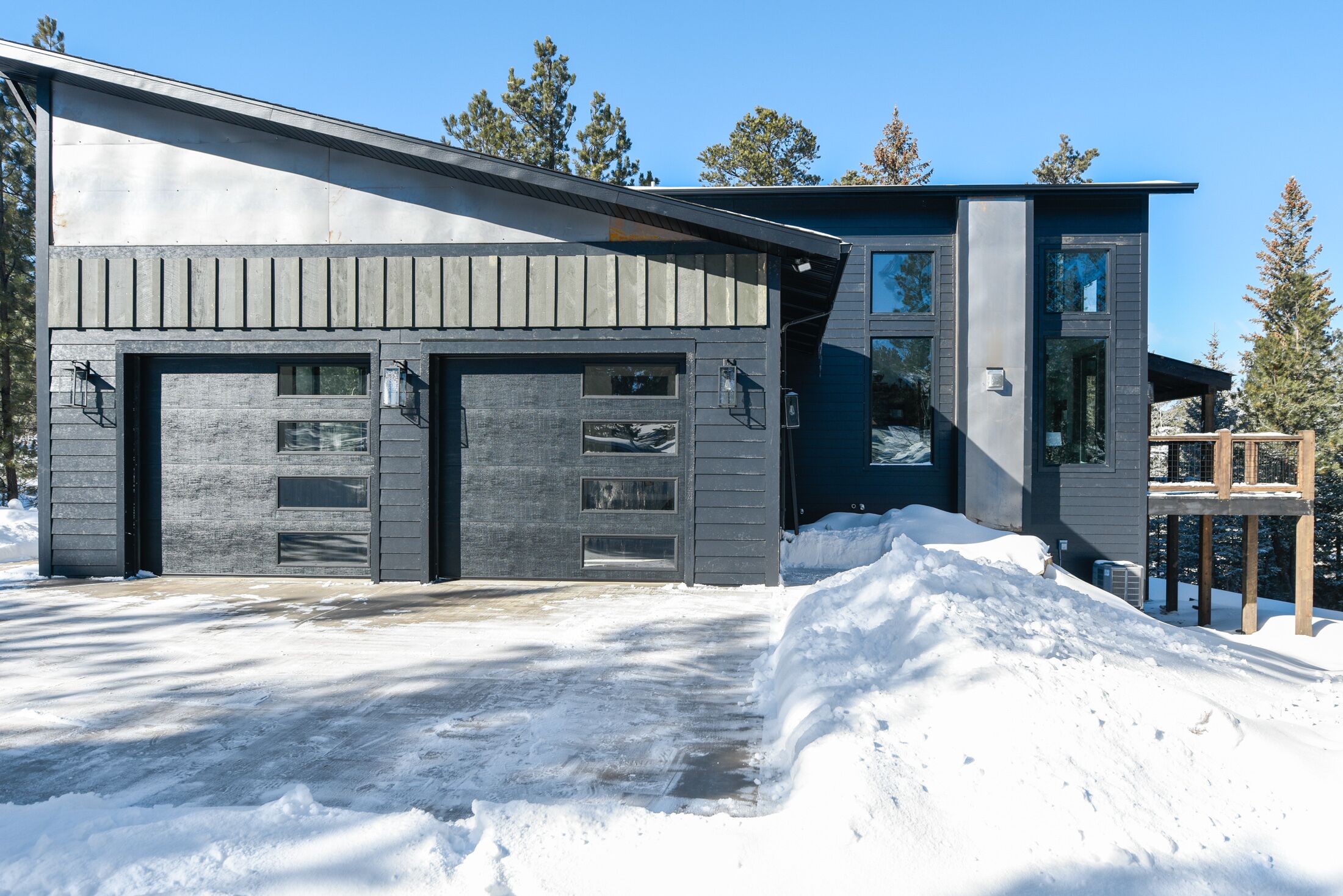 A modern two-story house with a garage and a covered porch area.