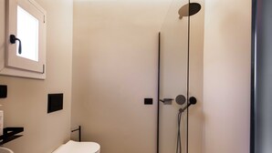 Un baño moderno con inodoro, lavamanos y ducha.