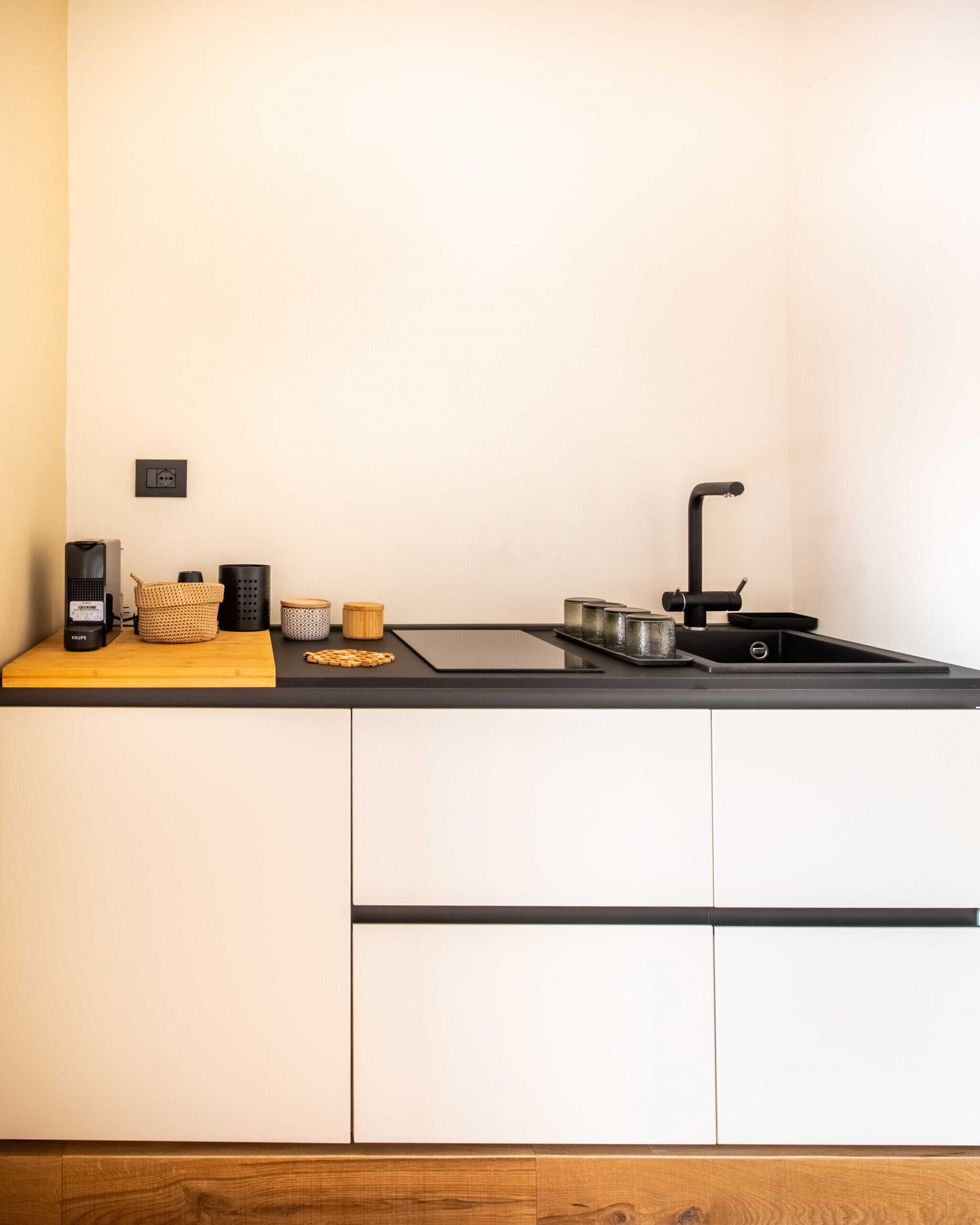 Eine moderne Küche mit schwarzem Arbeitsplatz, Spüle und Kaffeemaschine.
