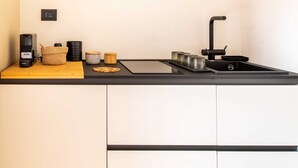 Eine moderne Küche mit schwarzem Arbeitsplatz, Spüle und Kaffeemaschine.