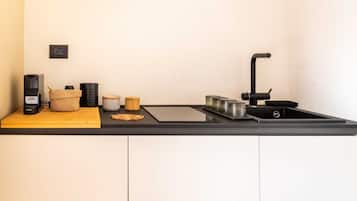 Eine moderne Küche mit schwarzem Arbeitsplatz, Spüle und Kaffeemaschine.