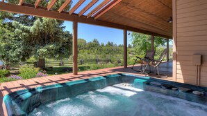 A hot tub under a wooden pergola with a view of a garden and trees. - Rancho Sendero Correo - Historic Home & Cabin on 300 Acres - Hot Tub (Hesperus)