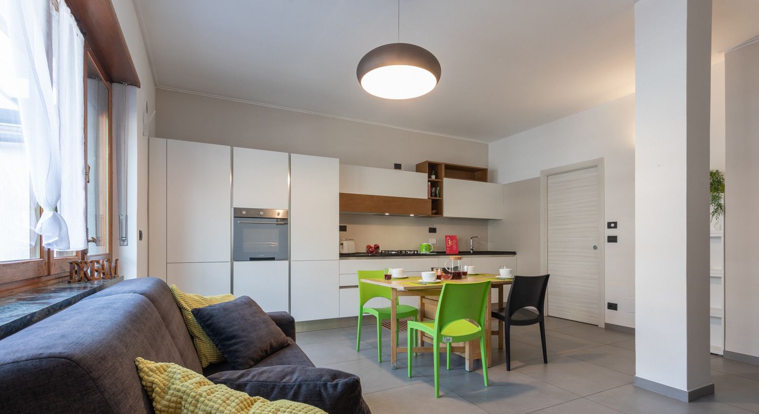 Un appartamento moderno con zona living, cucina e sala da pranzo.