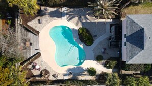 An aerial view of a residential property with a swimming pool, patio furniture, and surrounding landscaping. - 3 bedroom, 1 bath elevated home with private pool, walking distance to beach! (Isle of Palms)