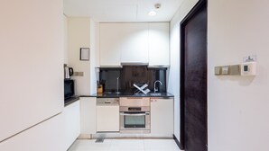 A compact kitchen with a dishwasher, oven, and microwave. - SuperHost - Deluxe Studio with Stunning Marina Views - JW Marriott Dubai Marina (Dubai)