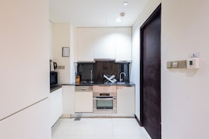 A compact kitchen with a dishwasher, oven, and a microwave.