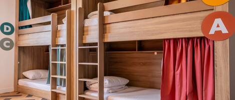 Dormitorio con literas, paredes de madera y suelo con estampado de espiga.