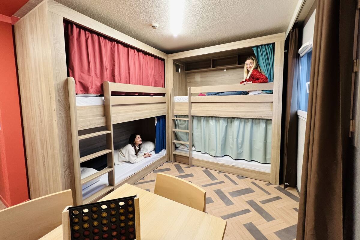 Een slaapkamer met een stapelbed, een tafel en een schaal vol kleurrijke voorwerpen.