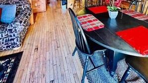 L’intérieur d’un chalet en bois comprend un coin repas, une cuisine et un canapé.