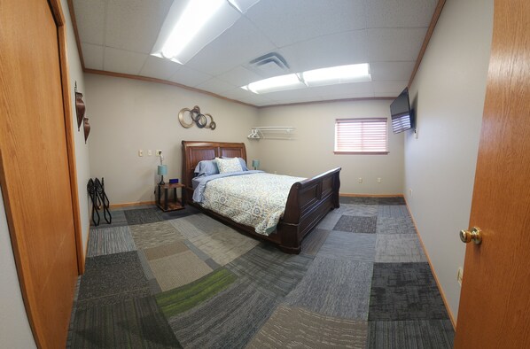 A bedroom with a bed, carpeted floor, wooden door, and a ceiling with fluorescent lights. - HUGE SPACE! 4 Bedrooms sleep up to 12. 6 additional bedrooms available. (Aberdeen)