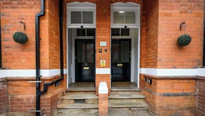 A brick building entrance with two doors, numbered 5 and 7, and a mailbox in front. - Sapphire Suite Moseley Birmingham STAE-Homes (Birmingham)