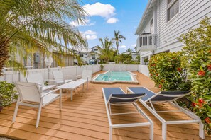 A wooden deck with white lounge chairs and a small pool. - Sea Jay: Canal front with dock, heated pool, lanai w/outdoor kitchen (Anna Maria)