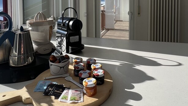 Een balkon met koffie, een schaal fruit en uitzicht op de lucht.