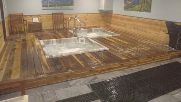 A sauna room with wooden benches, a hot tub, and two wall-mounted paintings. - 2-Bed. 2-Bath. Downtown Winter Park Condo CB2 (Winter Park)