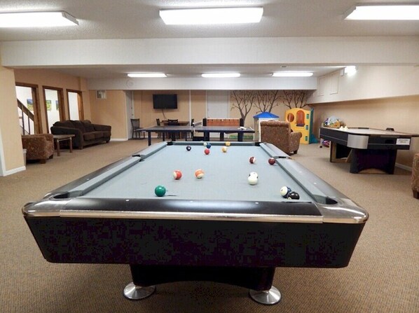 Enjoy a game of pool in this room's casual recreational area, featuring a pool table and comfortable seating.
