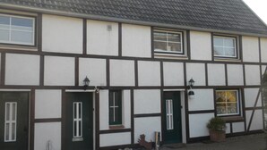 A traditional half-timbered house with a dark roof, white walls, and dark timber framing. - Casa del mar - Casa 2 (Cuxhaven)
