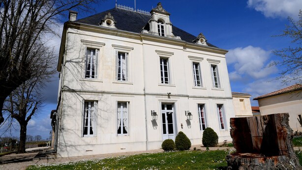 A large, white, multi-story building with symmetrical windows and a central entrance. - Château Tournefeuille in the heart of the vineyards! (Néac)