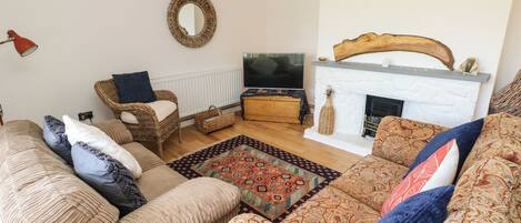 A cozy living room with a fireplace, a television, and comfortable seating.